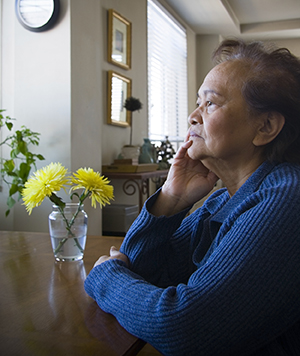 Woman sitting at table, looking sad.