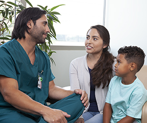 Healthcare provider talking to woman and boy.